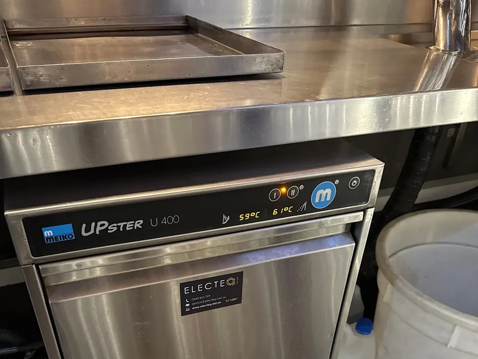 Commercial dishwasher repair: a Meiko undercounter dishwasher with wash and rinse temperatures on the display