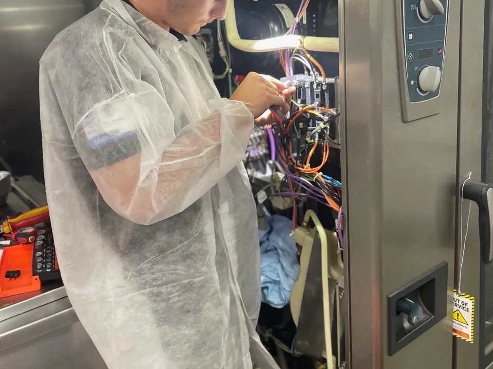 Commercial oven repairs Perth: Electeq technician repairing the wiring inside a Rational combi oven